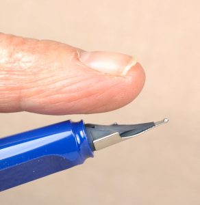 Place your index finger on the inkfeed to stabilize and support the fragile feed when you change a nib.