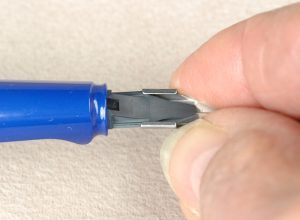 Turn the inkfeed upside down where you can see the tracks for the runners of the nib to slide into place. Gently pinch the side of the Lamy replacement nib and slowly slide or wiggle the nib into place.